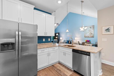 Kitchen featuring white cabinetry, sink, stainless