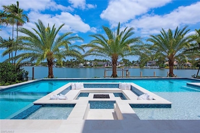 Pool featuring a patio, an in ground hot tub, and a water view