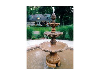 Beautiful fountain in street island by this home.
