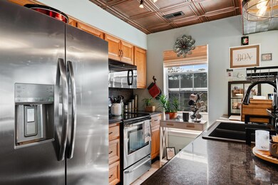 Kitchen with visible vents, dark stone counters, a