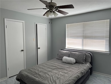 Bedroom with light gray laminate floors, ceiling f