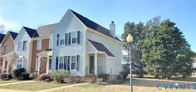 Traditional-style home with a chimney, a front lawn, and a shingled roof