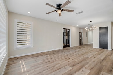 Unfurnished room featuring recessed lighting, light wood-style floors, a chandelier, and a ceiling fan