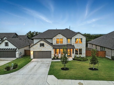 View of front facade featuring stone siding, driv