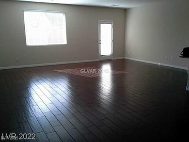 Empty room with dark wood-type flooring and baseboards