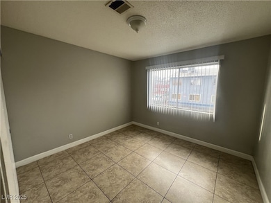 Unfurnished room with baseboards, visible vents, a