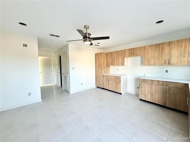 Kitchen featuring light countertops, ceiling fan, and light tile patterned flooring