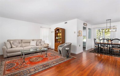Living room with baseboards, visible vents, and wo