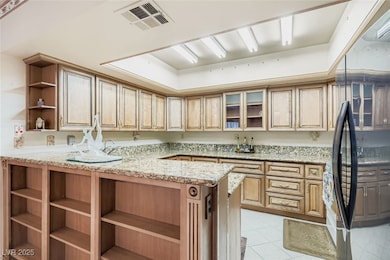 Kitchen featuring open shelves, glass insert cabinets, black appliances, a peninsula, and light tile patterned floors