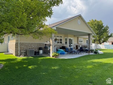 Back of house with a patio area, brick siding, and stucco siding