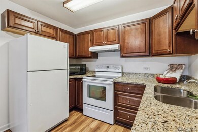 Updated kitchen with cherry stained wood cabinets and granite countertops
