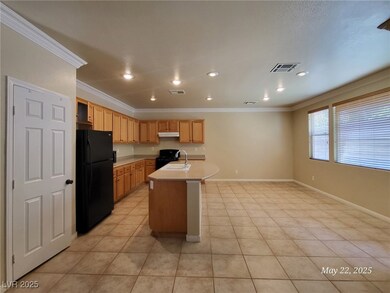 Kitchen with black appliances, ornamental molding,