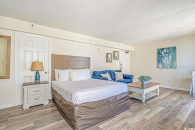 Bedroom with baseboards, a textured ceiling, and w