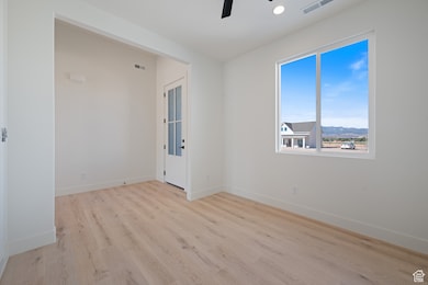 Empty room featuring light wood-type flooring, recessed lighting, and a ceiling fan