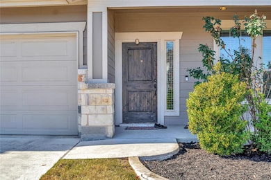 View of exterior entry with covered porch and stone siding