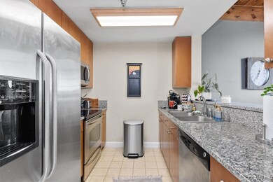 Kitchen featuring light tile floors, sink, applian