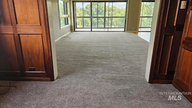 Hall featuring dark colored carpet and plenty of natural light