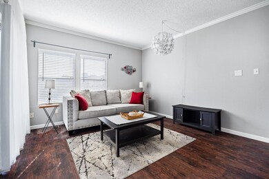 Living room with crown molding, a textured ceilin