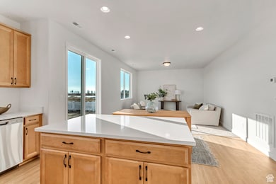 PHOTOS OF A SIMILAR HOME. COLORS, OPTIONS, AND FEATURES WILL VARY. Kitchen featuring light wood-type flooring, recessed lighting, stainless steel dishwasher, and light brown cabinetry