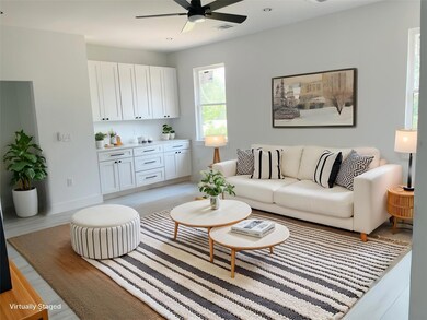 Living area featuring a ceiling fan and baseboards