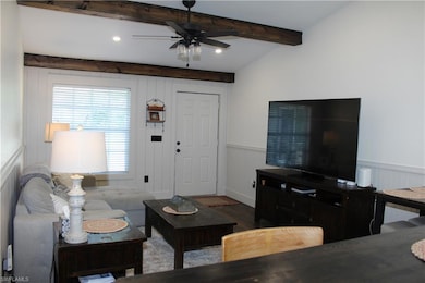 Living area featuring a ceiling fan, dark wood-style flooring, beamed ceiling, recessed lighting, and wainscoting