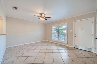 Foyer with ceiling fan, crown molding, and light 