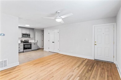 Unfurnished living room with ceiling fan and light wood-style flooring