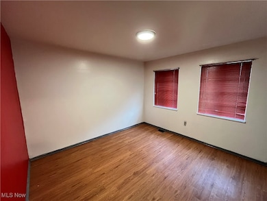 Unfurnished room with wood finished floors and baseboards