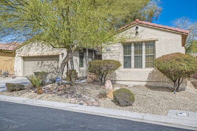 View of front facade with a tile roof, concrete driveway, a garage, and stucco siding