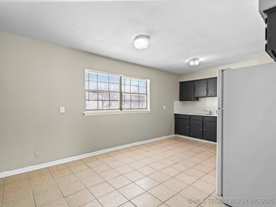Kitchen, note the cabinets and the tile floor