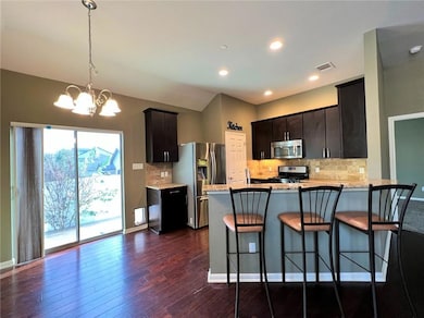 Kitchen featuring backsplash, pendant lighting, stainless steel appliances, a peninsula, and recessed lighting