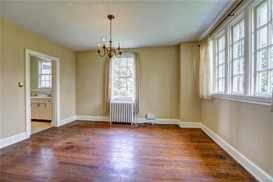 Formal dining room with original hardwood floors and swinging door access to large kitchen.