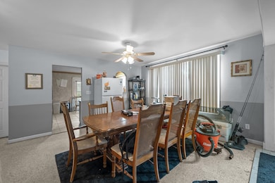 Dining room with ceiling fan and dark aggregate flooring