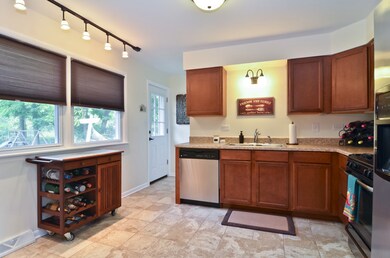 Kitchen with newer cabinets, tile floors, and stai
