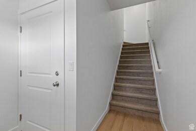 Staircase with wood finished floors and baseboards