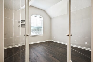 A peek into the formal study behind French doors brings to mind decorating ideas for the ideal in-home office or formal living room featuring a vaulted ceiling and gorgeous wood-look tile.