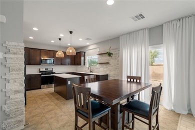 Kitchen featuring a center island, stainless steel appliances, dark brown cabinets, open shelves, and decorative light fixtures