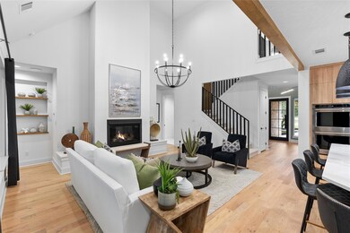 Living room featuring visible vents, a towering c
