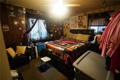 Carpeted bedroom featuring multiple windows and ceiling fan
