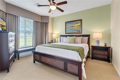 Bedroom with ceiling fan and light carpet