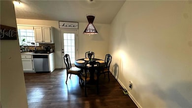 Dining space with dark wood-style floors, lofted c