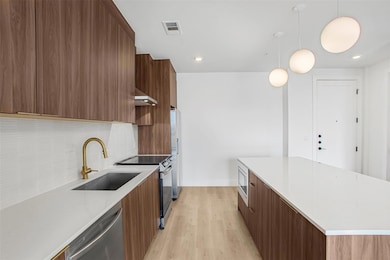 Kitchen with a sink, light wood-style floors, sta