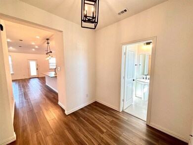Corridor featuring dark wood finished floors, visible vents, and baseboards
