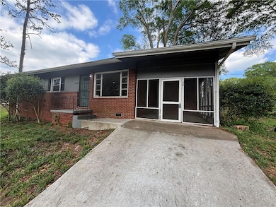 Back of house featuring brick siding, crawl space,