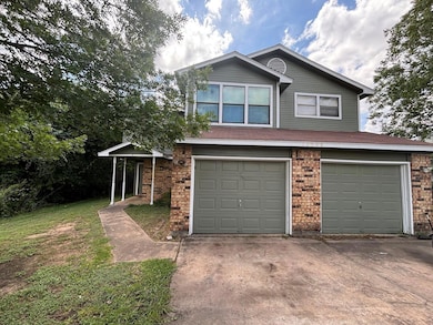 View of front facade featuring a garage, concrete