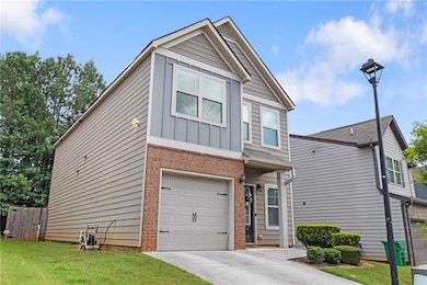 View of front facade featuring brick siding, an attached garage, board and batten siding, and concrete driveway