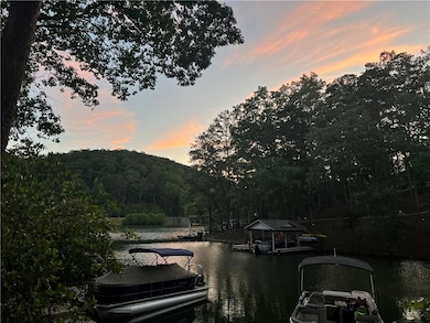 Dock area with a water view and a wooded view