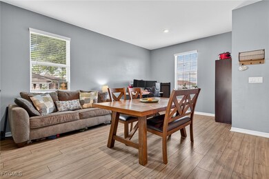 Dining room with light wood finished floors and recessed lighting
