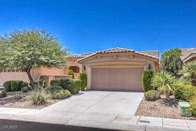 Mediterranean / spanish home with stucco siding, a garage, a tiled roof, and driveway