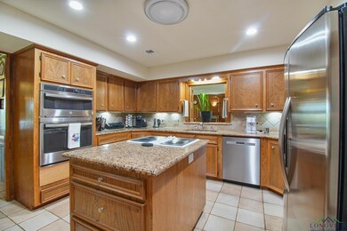 Kitchen with appliances with stainless steel finishes, brown cabinets, and recessed lighting
